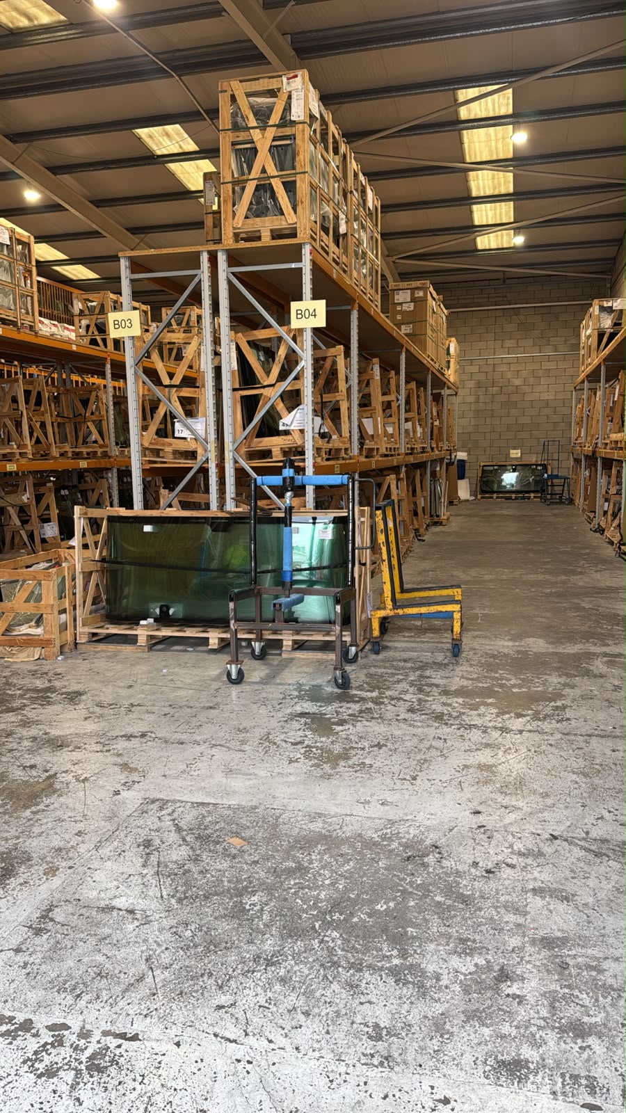 Warehouse aisle with automotive glass racked in wooden crates
