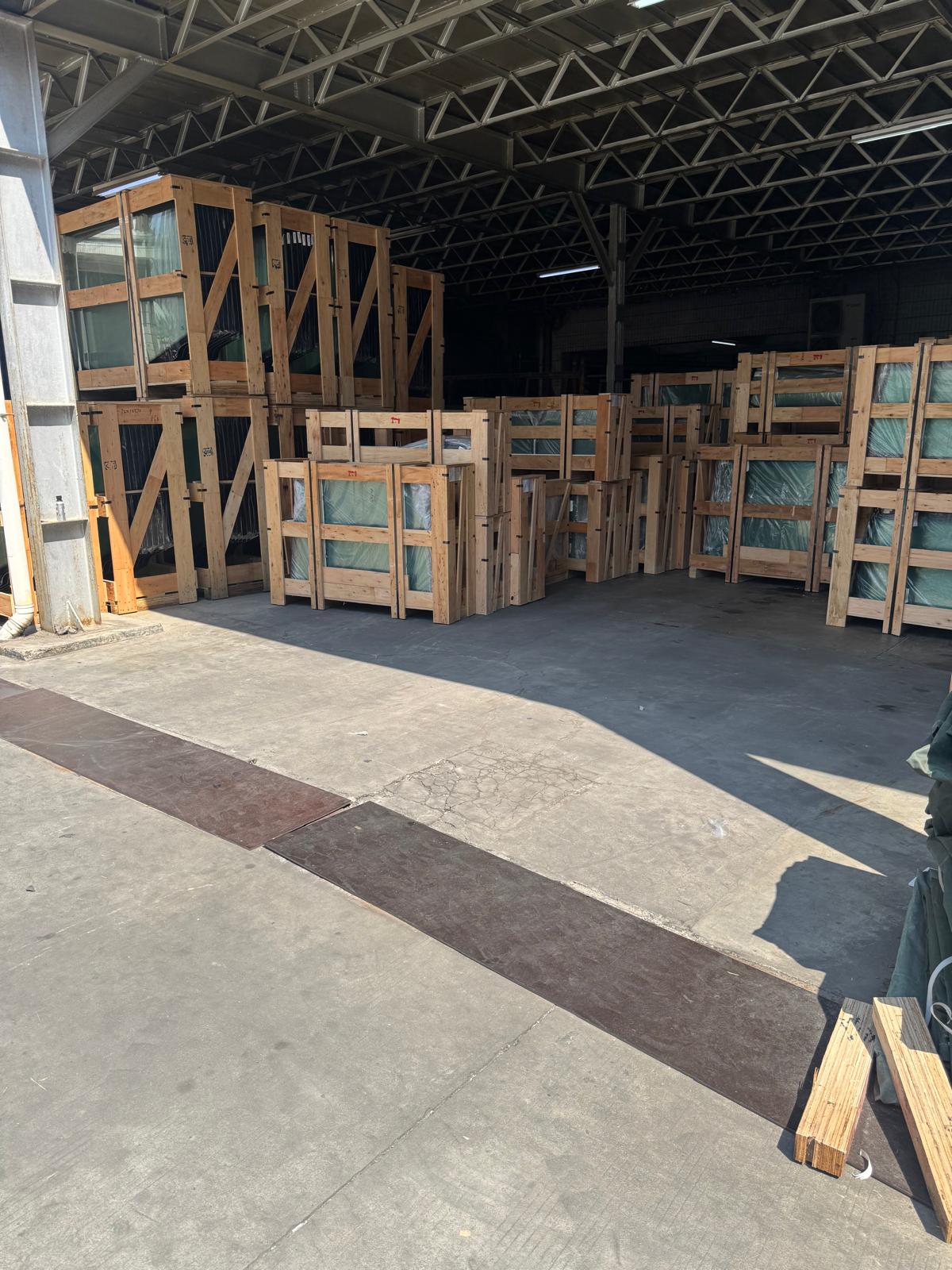 Rows of crated automotive glass waiting under the warehouse roof